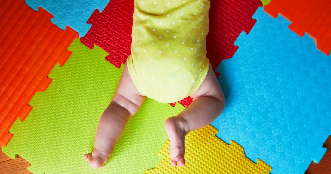 Baby girl lying on play mat