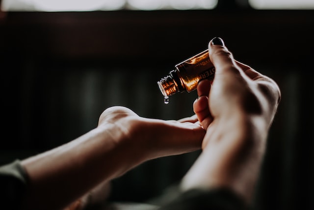 a person drips medicine from a bottle onto his hand