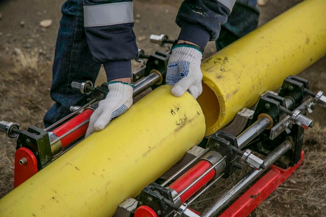 a-person-holding-yellow-pipes