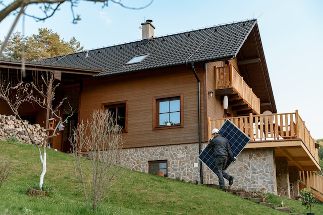 A man worker carrying solar panel for installing solar modul system on house