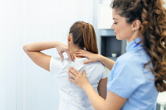 Physiotherapist doing healing treatment on womans back