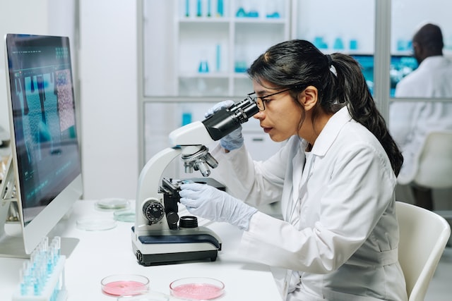 biochemist looking in microscope