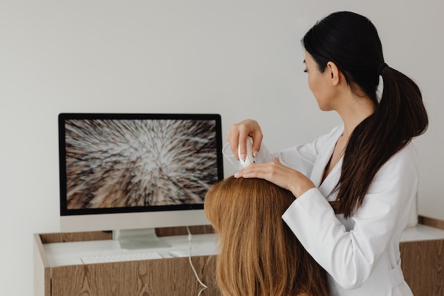 the trichologist checks the condition of the patient's hair