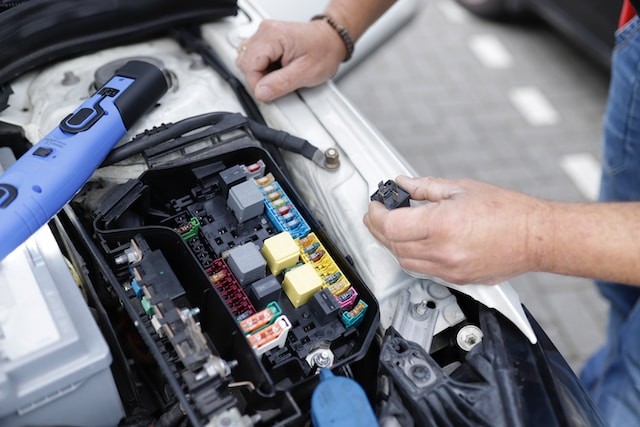 man is working on a cars engine