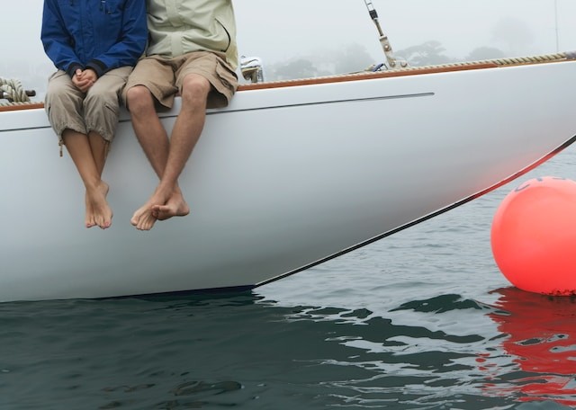 persons sitting on yacht with fender