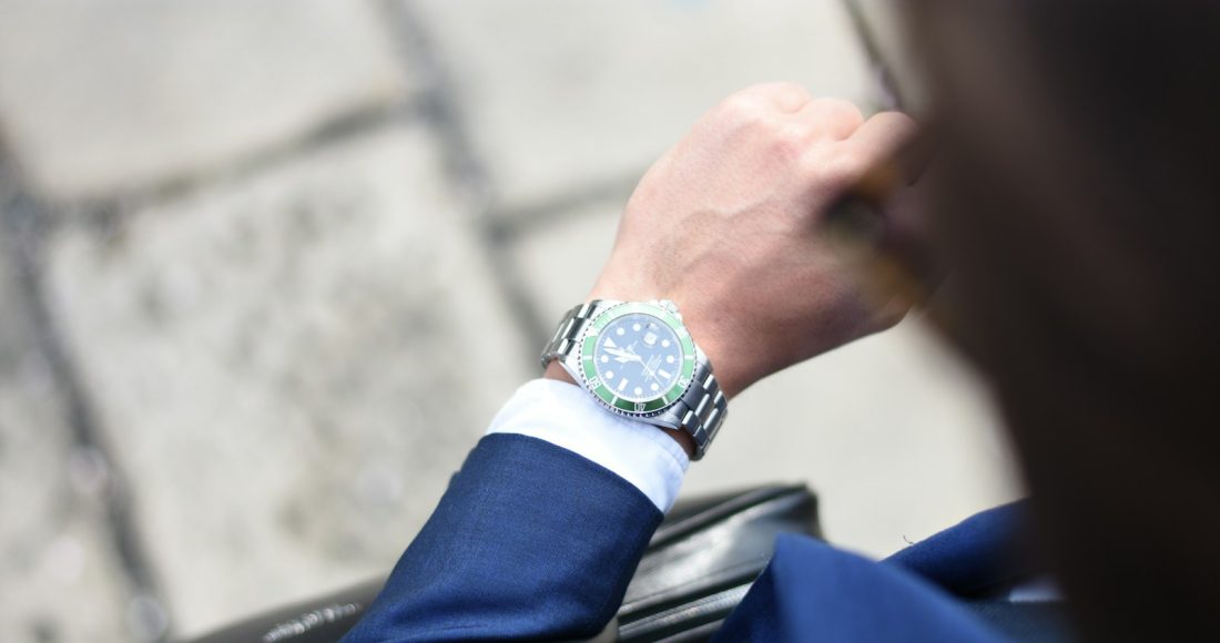 person looking at silver-colored analog watch