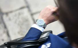 person looking at silver-colored analog watch