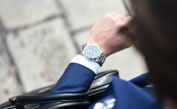 person looking at silver-colored analog watch