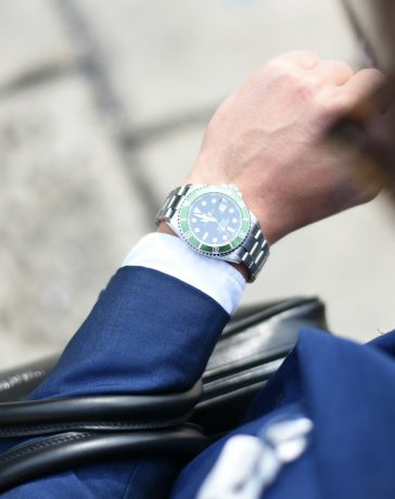 person looking at silver-colored analog watch