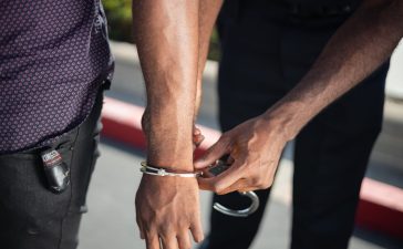 police-officer-putting-handcuffs-on-another-person