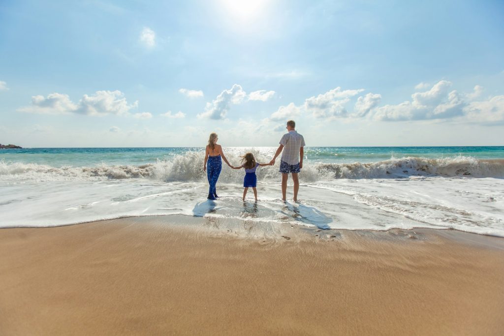 man-woman-and-child-holding-hands-on-seashore