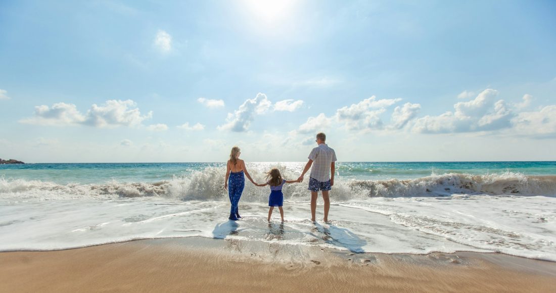 man-woman-and-child-holding-hands-on-seashore