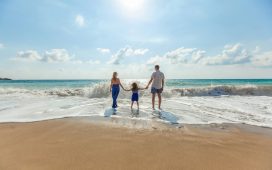 man-woman-and-child-holding-hands-on-seashore