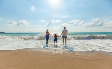 man-woman-and-child-holding-hands-on-seashore