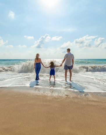 man-woman-and-child-holding-hands-on-seashore