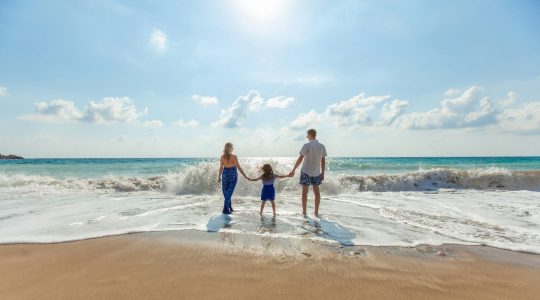 man-woman-and-child-holding-hands-on-seashore