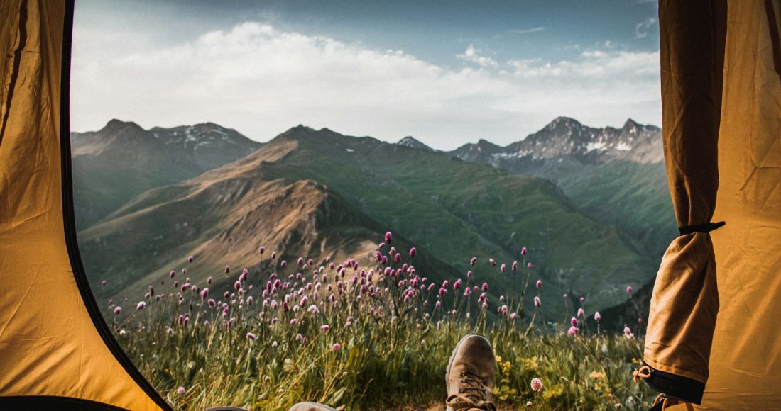 person-lying-inside-tent-and-overlooking-mountain