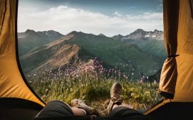 person-lying-inside-tent-and-overlooking-mountain