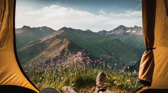 person-lying-inside-tent-and-overlooking-mountain