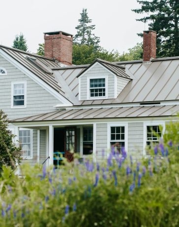 white-and-gray-wooden-house-surrounded-by-green-plants