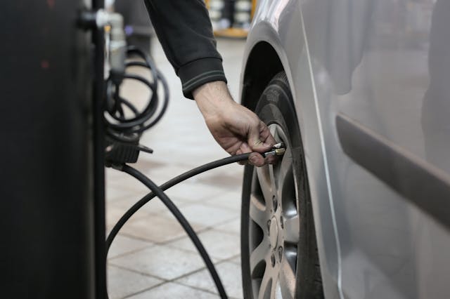 person-in-black-long-sleeve-shirt-holding-black-metal-bar-near-black-tire