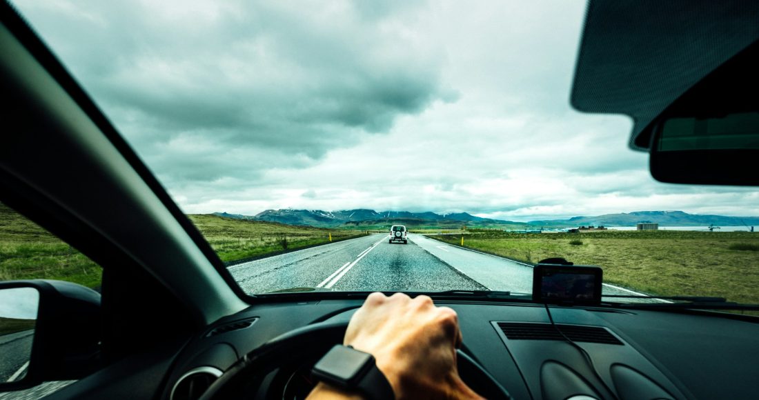 person-driving-car-near-vehicle-under-nimbus-cloudes