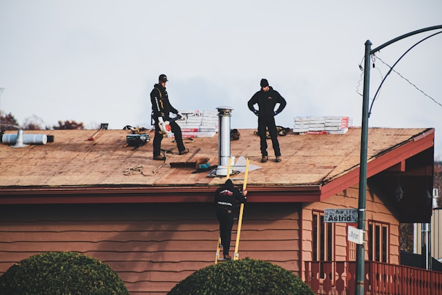 a-couple-of-men-standing-on-top-of-a-roof