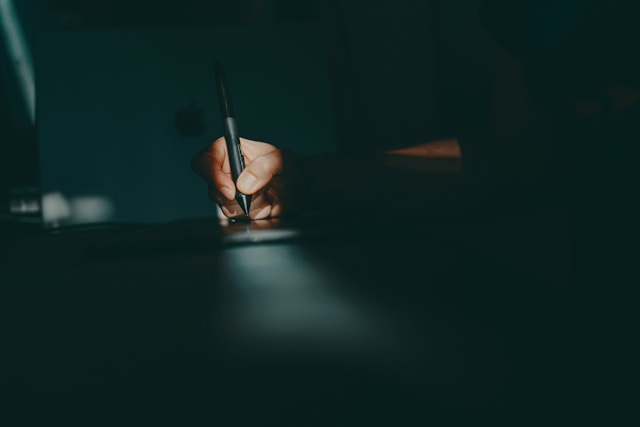a-person-writing-on-a-piece-of-paper-with-a-pen